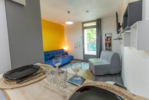 - un salon avec une table et des verres à vin dans l'établissement Chez vous à Evry, Évry-Courcouronnes