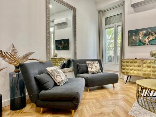 uma sala de estar com duas cadeiras e um espelho em Ô portes du Palais em Avignon