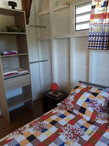 a bedroom with a bed with a colorful quilt at Villa des fleurs in Pointe-Noire