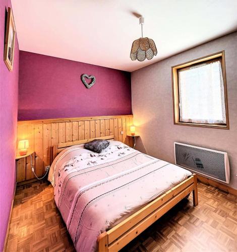 - une chambre avec un lit et un mur violet dans l'établissement Chalet Les Airelles - APPARTEMENT DANS CHALET AVEC GARAGE MAE-9054, à Villarembert