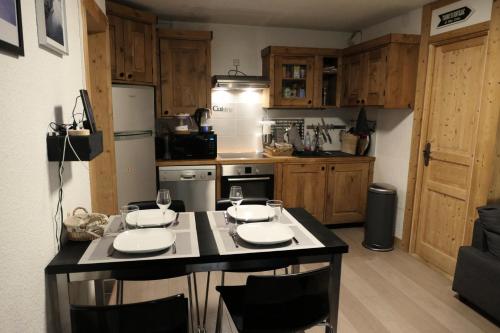 - une cuisine avec un îlot doté de 2 verres dans l'établissement Les Chalet Du Soleil - Chalets du Soleil 9 MAE-6344, à Saint-Gervais-les-Bains