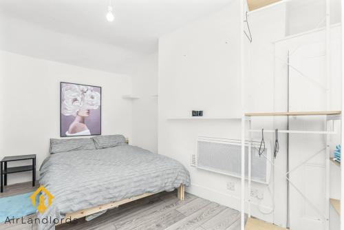 Biała sypialnia z łóżkiem i wentylatorem w obiekcie Fab 3bed 3bath Flat Kings Cross w Londynie