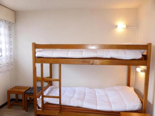 two bunk beds in a room with white sheets at Résidence Bel'aval - 3 Pièces pour 6 Personnes 364 in Les Contamines-Montjoie