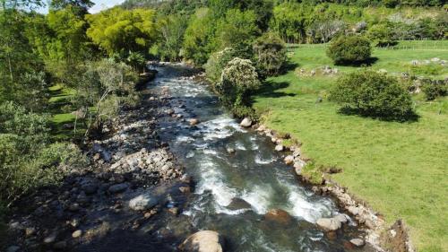 an aerial view of a river with rocks in a field at chez Yannick Hospedaje Los Amigos in Salento