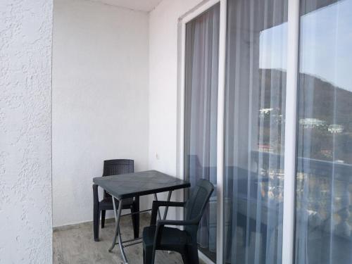 stół i krzesła w pokoju z oknem w obiekcie Geno Guest House w mieście Kvariati