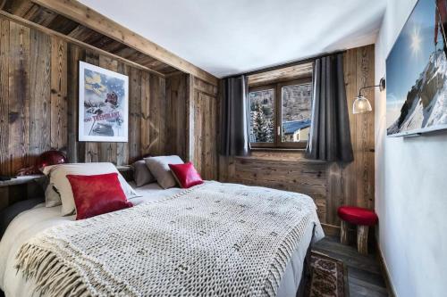 um quarto com uma cama com almofadas vermelhas em Residence La Canadienne - 4 Pièces pour 6 Personnes 564 em Val dʼIsère