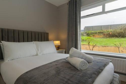 a bedroom with a large bed with a window at Teach an Choill, Dingle in Dingle