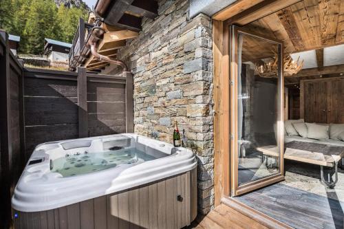 eine Whirlpool-Badewanne auf einer Terrasse in der Unterkunft Residence La Canadienne - 4 Pièces pour 6 Personnes 564 in Val dʼIsère
