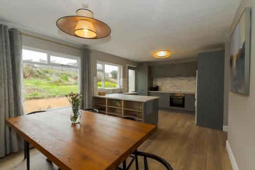 a kitchen and dining room with a wooden table at Teach an Choill, Dingle in Dingle