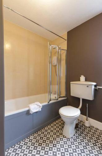 a bathroom with a toilet and a bath tub at Teach an Choill, Dingle in Dingle