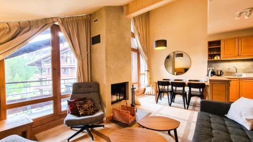 a living room with a couch and a fireplace at Résidence Les Terrasses D'eos - Appartement confortable · Accès direct aux pistes · Piscine · Spa · WIFI gratuit et illimité MAE-6164 in Magland