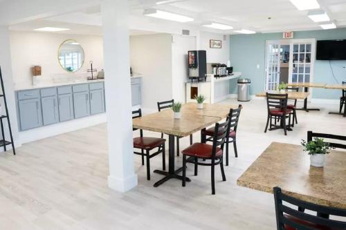 a dining room with tables and chairs and a kitchen at Rodeway Inn Clearwater - Central in Clearwater