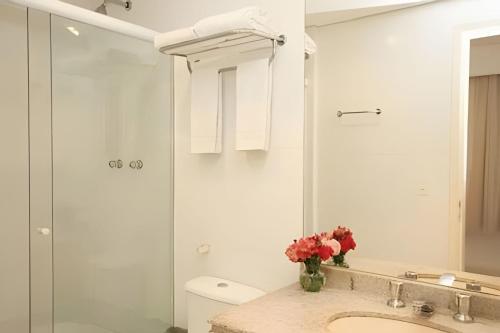 um banheiro com pia, vaso sanitário e chuveiro em Ibirapuera Flat em São Paulo