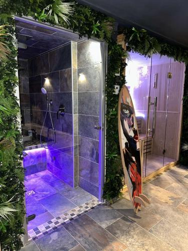 a bathroom with a shower with a surfboard in it at Pool47spa in Précy-sur-Oise