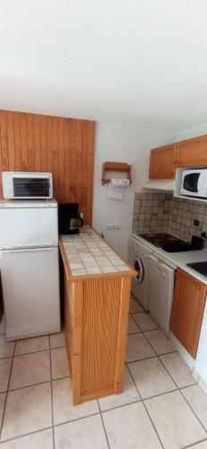 Il comprend une cuisine équipée d'un réfrigérateur blanc et d'une cuisinière. dans l'établissement Résidence Le Chardonnet - Appartement à 200 m des pistes avec vue MAE-9544, à Champagny-en-Vanoise