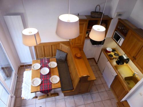 - une vue de tête sur une petite cuisine avec une table dans l'établissement Résidence Palmes D'or - Palmes d'Or B33 MAE-5784, aux Contamines-Montjoie