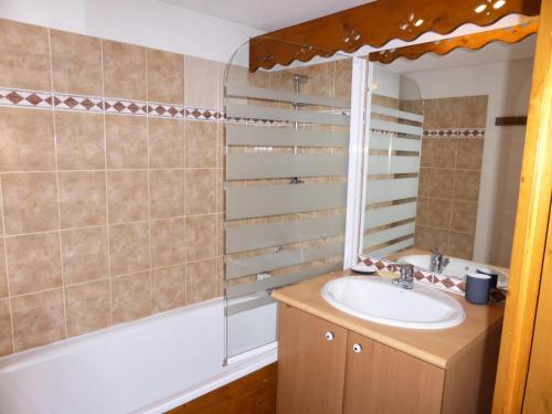 une salle de bain avec un lavabo, un miroir et une baignoire dans l'établissement Résidence Palmes D'or - Palmes d'Or B33 MAE-5784, aux Contamines-Montjoie