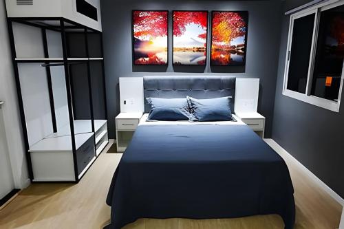 a bedroom with a bed with four paintings on the wall at Paulista Premium Flat in São Paulo