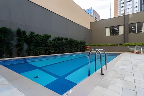 a swimming pool in front of a building at Paulista Premium Flat in São Paulo