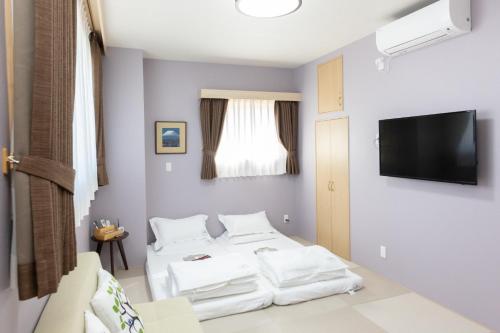 two beds in a room with a tv on the wall at Light Hotel - Vacation STAY 91078v in Tokyo