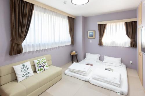a bedroom with two beds and a couch at Light Hotel - Vacation STAY 91078v in Tokyo