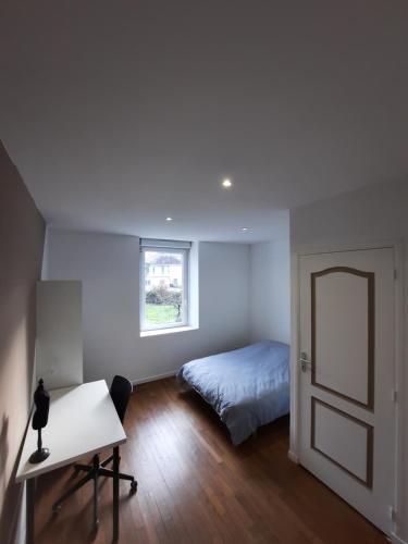 sypialnia z łóżkiem, biurkiem i lustrem w obiekcie Belle Suite privative centre vesoul w mieście Vesoul