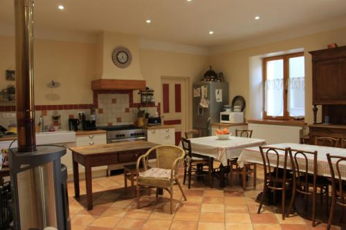 uma cozinha com mesa e cadeiras e uma sala de jantar em Grande maison familiale en Ubaye em Faucon-de-Barcelonnette