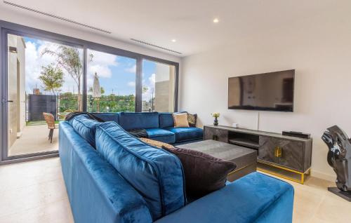 a living room with a blue couch and a tv at 3 Bedroom Amazing Home In Torre Pacheco in Torre-Pacheco