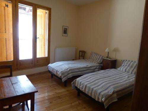 um quarto com duas camas e uma mesa em Grande maison familiale en Ubaye em Faucon-de-Barcelonnette