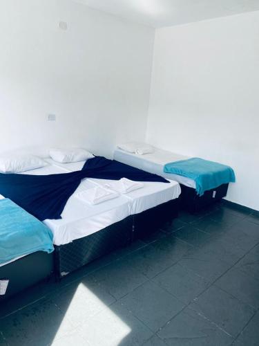 two beds are sitting in a room with at Hotel Beira Rio Guararema in Guararema
