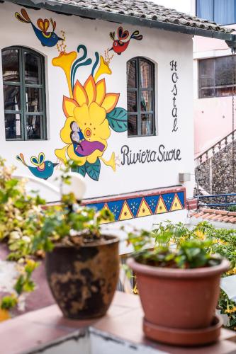 a building with a sunflower painted on it at Hostal Riviera Sucre in Otavalo