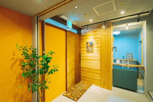 a room with yellow walls and a door with a plant at Noasobi lodge - Vacation STAY 80823v in Arao