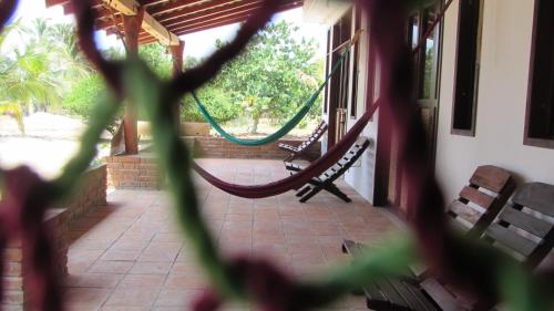 a porch with two benches and a hammock at Hab #4 La Casa Del Profe Salo in Santa María Tonameca