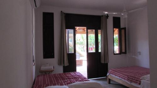 a bedroom with two beds and an open door at Hab #4 La Casa Del Profe Salo in Santa María Tonameca