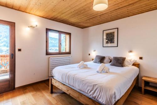 - une chambre avec un grand lit blanc et 2 oreillers dans l'établissement Chalet L'ourson Blanc Morzine - 3 Pièces pour 6 Personnes 514, à Morzine