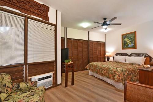 een slaapkamer met een bed en een plafondventilator bij Kuleana Resort #105 in Kahana