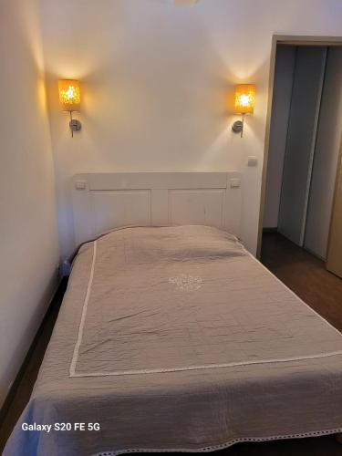 Ce lit se trouve dans un dortoir doté de 2 lumières sur le mur. dans l'établissement Loris, à Sanary-sur-Mer