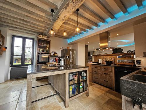 a large kitchen with wooden ceilings and a large island at Maison familiale au cœur du D-DAY in Vaux-sur-Aure