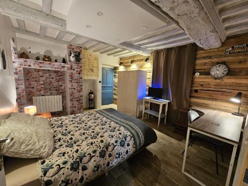 a bedroom with a bed and a desk and a clock at Maison familiale au cœur du D-DAY in Vaux-sur-Aure