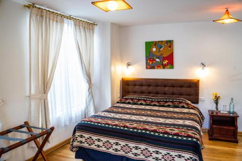 a bedroom with a bed and a window at Hostal Riviera Sucre in Otavalo