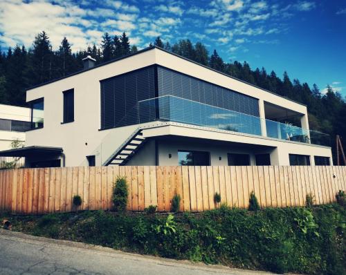 a white house with a fence in front of it at Jack's Apartment in Werfenweng