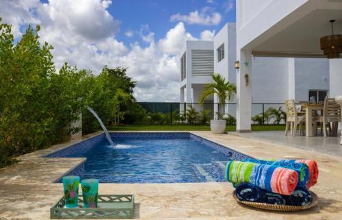 a swimming pool with a water fountain in a backyard at Dream villa with pool & garden view in Vista Cana in Punta Cana