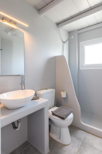 a white bathroom with a sink and a toilet at ELEVEN KEYS APARTMENTS in Vrisi/ Mykonos