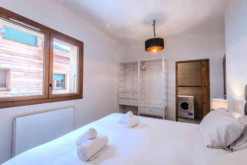 biała sypialnia z 2 ręcznikami na łóżku w obiekcie Chalets Brunes - 3 Pièces pour 6 Personnes 544 w mieście Morzine