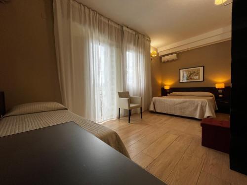 een hotelkamer met 2 bedden en een raam bij La Maison Des Rêves in Siracusa