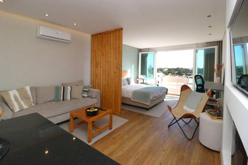 a living room with a couch and a bed at Vilamoura Sunrise in Quarteira