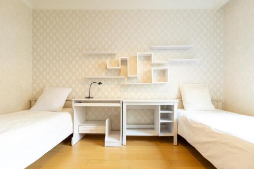 Habitación con 2 camas, escritorio y estanterías en Spacious flat 120m2 close to Eiffel Tower en París