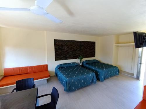 a bedroom with two beds and a couch at VILLAS DULCE SUEÑOS RESIDENCIAL in Rincon de Guayabitos