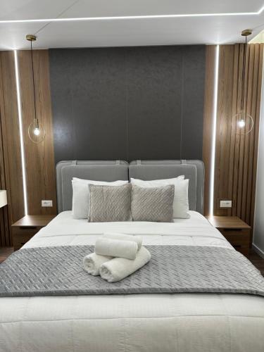 a large white bed with two towels on it at Green Villa with Private Pool in Durrës