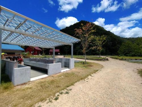 um pavilhão num parque com uma montanha ao fundo em Ayu no Sato Park Campsite - Vacation STAY 42240v em Shōbara